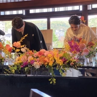 鴨川をバックにした高砂、素敵な装花