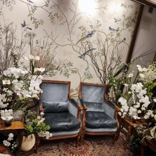 白やグリーンをメインとした装花に。椅子と壁紙もおしゃれ。