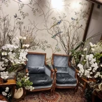 白やグリーンをメインとした装花に。椅子と壁紙もおしゃれ。