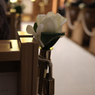 参列者の椅子の端には白い花の造花がある