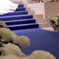 青いウェディングロードに白いウェディングドレスが映えます