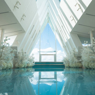 白を基調としたチャペル、正面はガラス張り、青のバージンロード