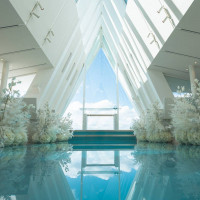 白を基調としたチャペル、正面はガラス張り、青のバージンロード