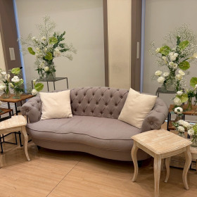 新郎新婦が座るソファと緑と白の装飾