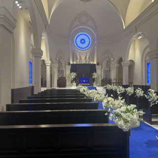 青いバージンロードにウエディングドレスがよく映える