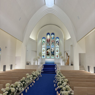 青いバージンロードとステンドグラスがとてもよかった。