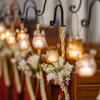 挙式会場のゲストの椅子には本物のロウソクの光が輝いてます。